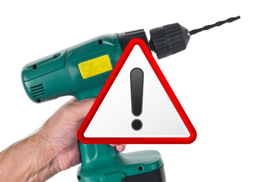 locksmith carrying a drill with a warning sign